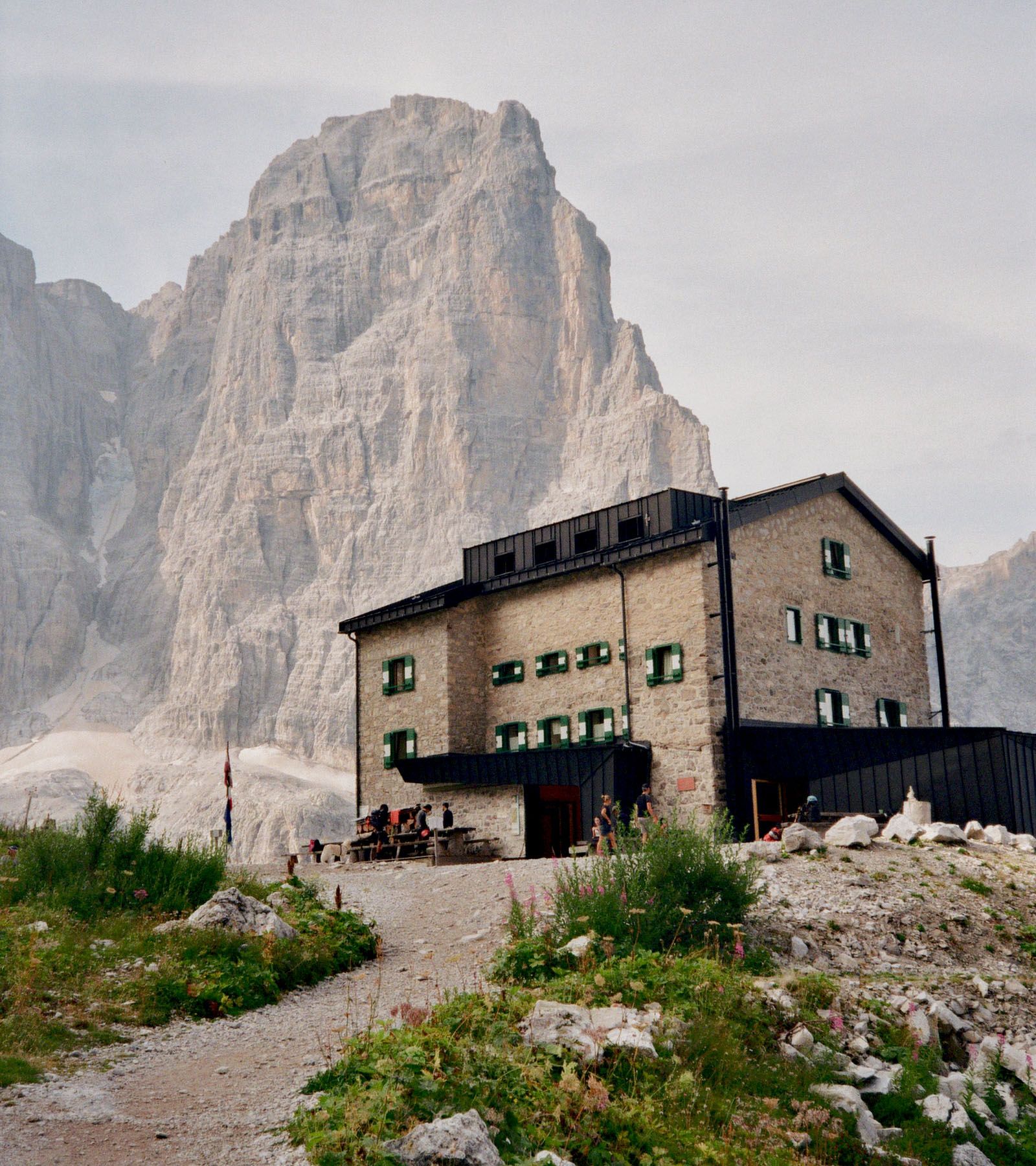 Un rifugio ai piedi di una grande parete rocciosa